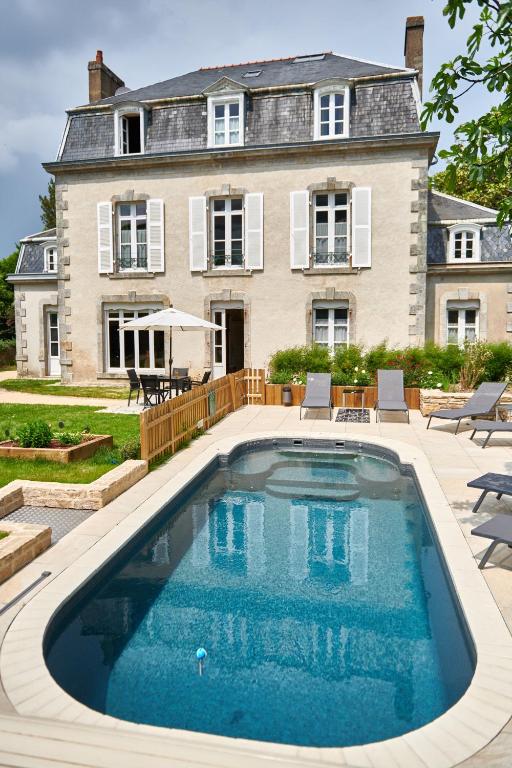 a house with a swimming pool in front of a house at Maison de la Garenne & Spa in Vannes