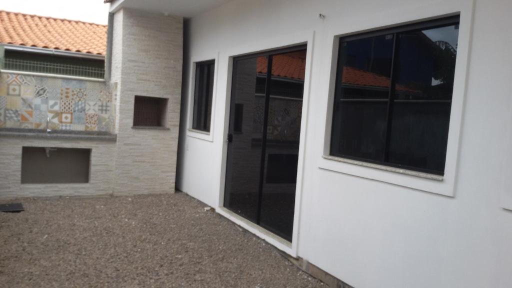 an entrance to a building with a large glass door at Casa Barra de Ibiraquera. Há menos de 5minutos caminhando da lagoa e do mar. in Barra de Ibiraquera