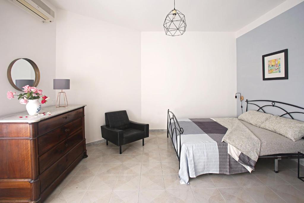 1 dormitorio con 1 cama, vestidor y silla en Ciraccio Apartments, en Procida