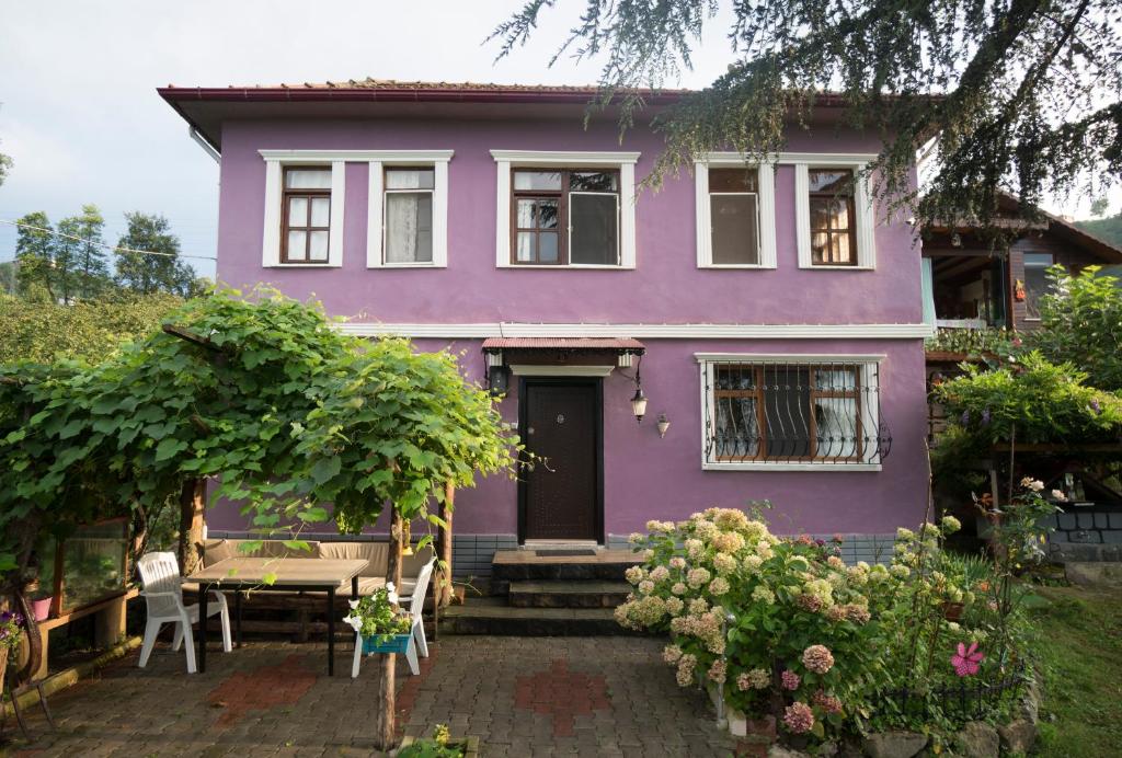 トラブゾンにあるVilla Banizo Great Black Sea View Village Houseの紫の家 テーブルと椅子付