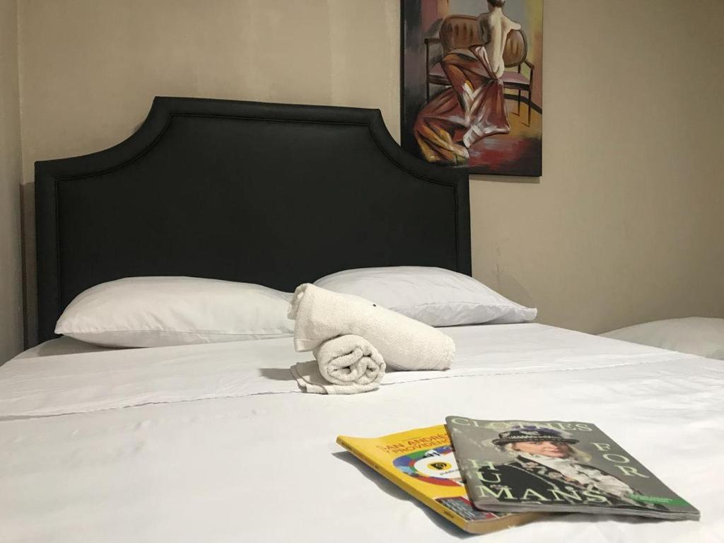 een bed met een boek en een tijdschrift erop bij Tropical Dreams in San Andrés