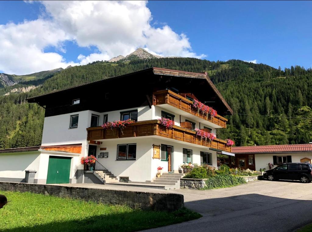 a building with a balcony with a mountain in the background at Haus Moosbrugger in Bach