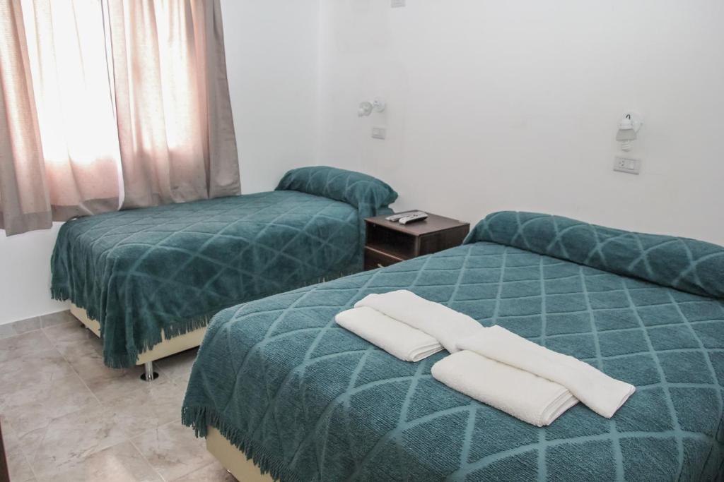 duas camas num quarto de hotel com toalhas em Departamentos El Alamo em Comandante Luis Piedrabuena