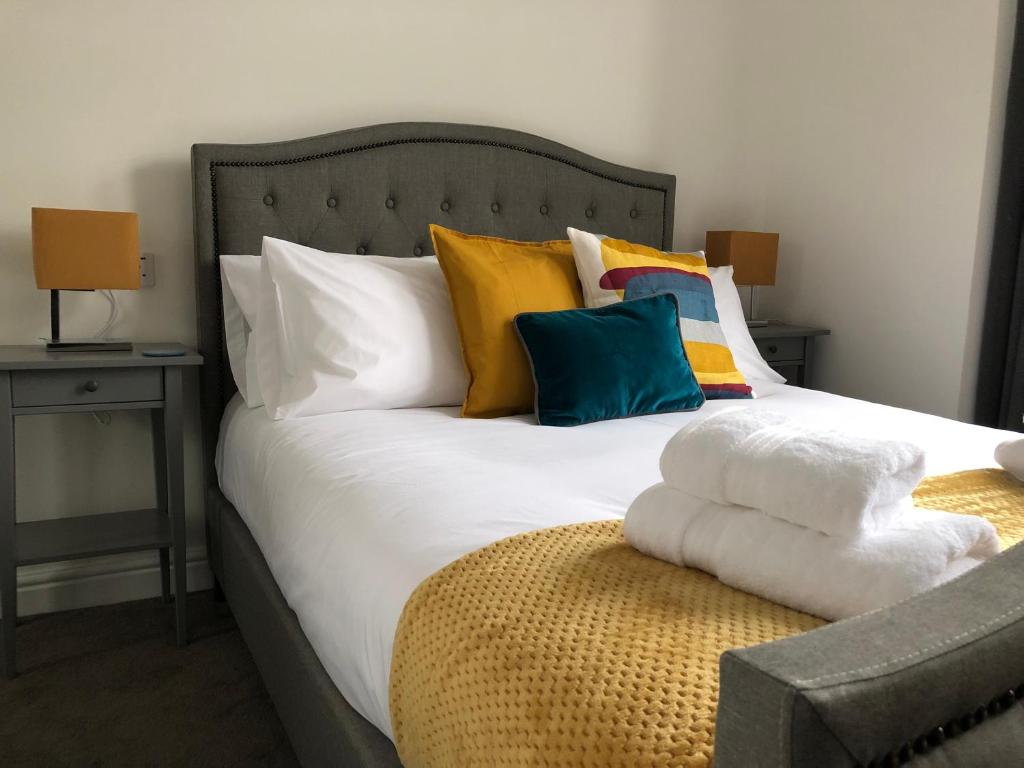 een bed met een stapel kussens erop bij Dryburgh Apartment No3 in Inverness