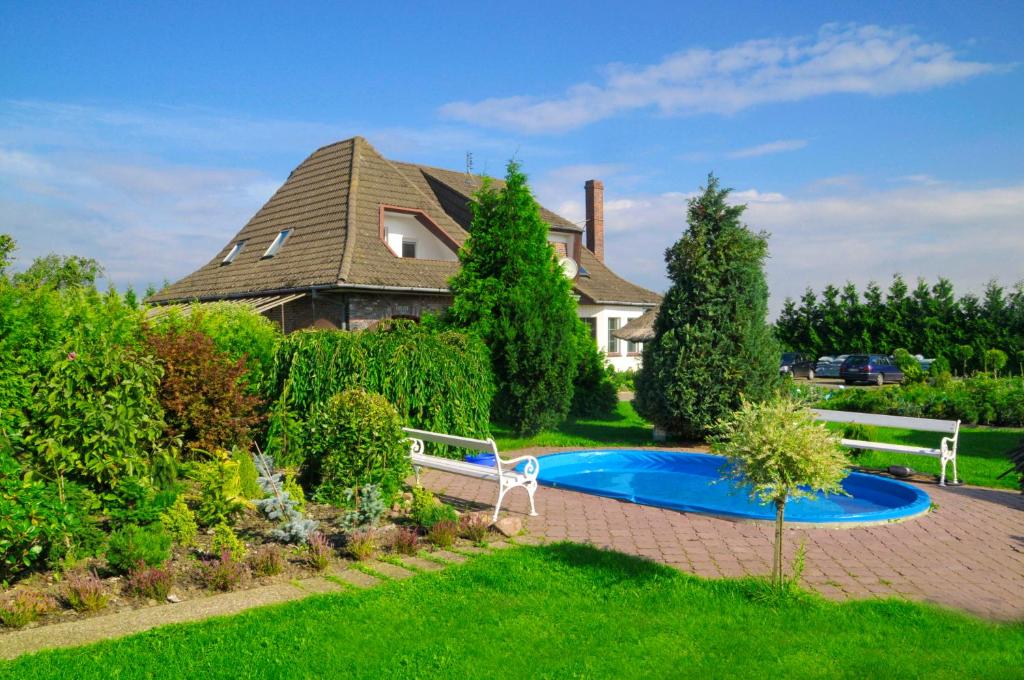 a house with a swimming pool in a yard at Pensjonacik Ewa in Darłowo