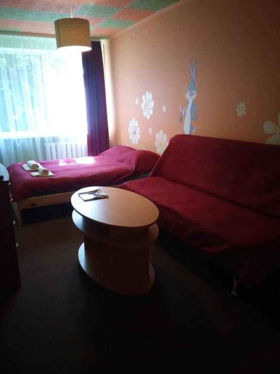 - une chambre avec 2 lits, une table et une fenêtre dans l'établissement Nakvynė Anykščių centre, à Anykščiai