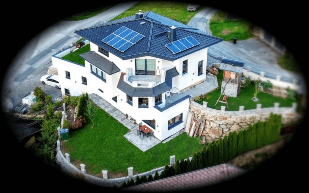 una gran casa blanca con paneles solares en el techo en Bergschlössl, en Goldegg