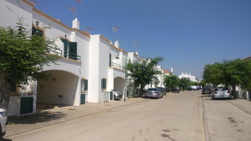 uma rua com edifícios e carros estacionados ao lado de uma estrada em Manta Rota Beach Haven na Manta Rota