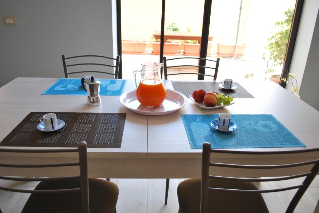 een tafel met een fruitschaal en een glas sinaasappelsap bij Narciso in Portopalo
