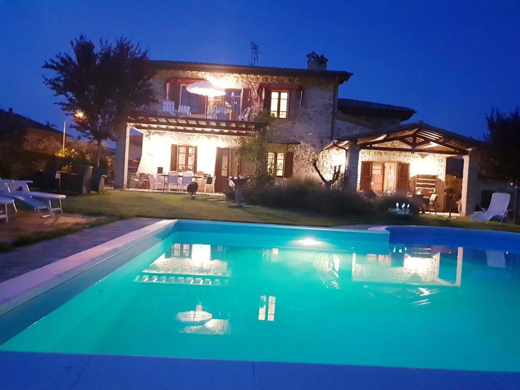 a house with a swimming pool at night at Il Belvederino in Brufa