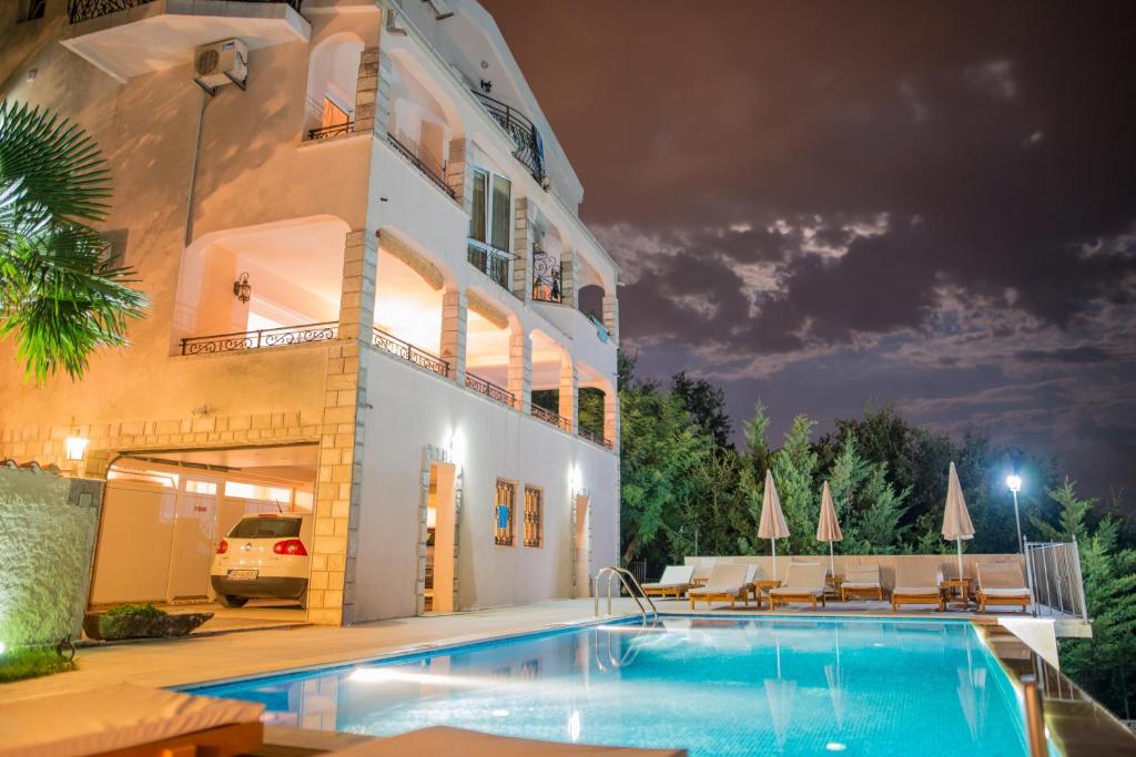een zwembad voor een huis 's nachts bij Villa Del Mar in Sutomore
