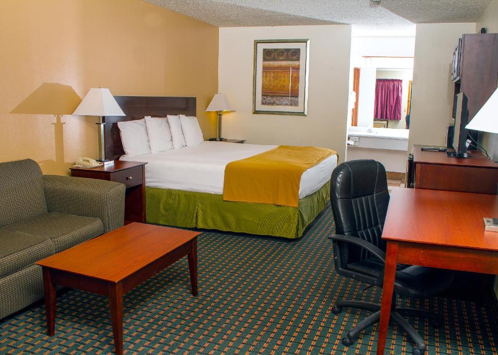 Budget Inn & Suites Guymon في Guymon: غرفة في الفندق مع سرير ومكتب