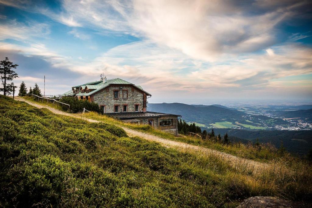 a house on top of a grassy hill at Chata Jiriho na Seraku in Bělá pod Pradědem