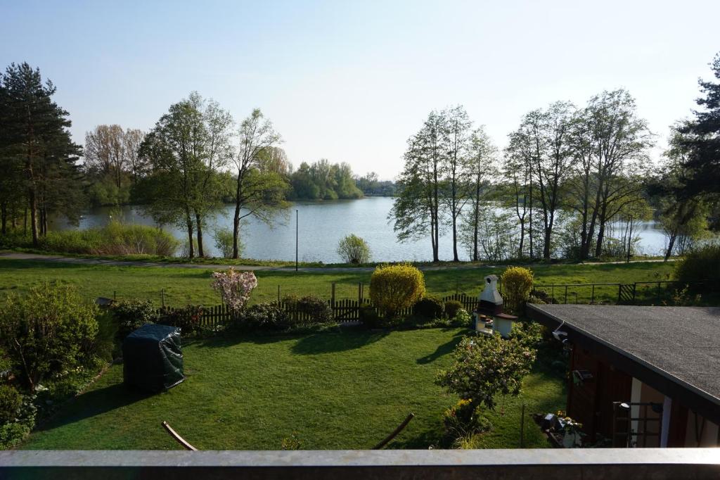 a woman standing in a yard with a view of a lake at Ferienwohnung am See in Bad Lippspringe