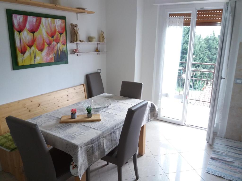 a dining room table with chairs and a painting on the wall at Ca Prandel in Levico Terme