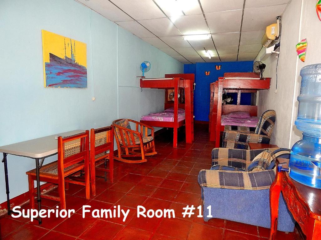 Zimmer mit einem Tisch, Stühlen und Etagenbetten in der Unterkunft Rositas Hotel in San Juan del Sur