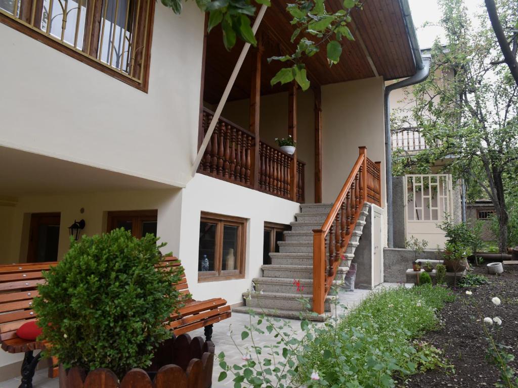 a house with a staircase and benches in front of it at Guest House Kartuli Suli in Tʼelavi