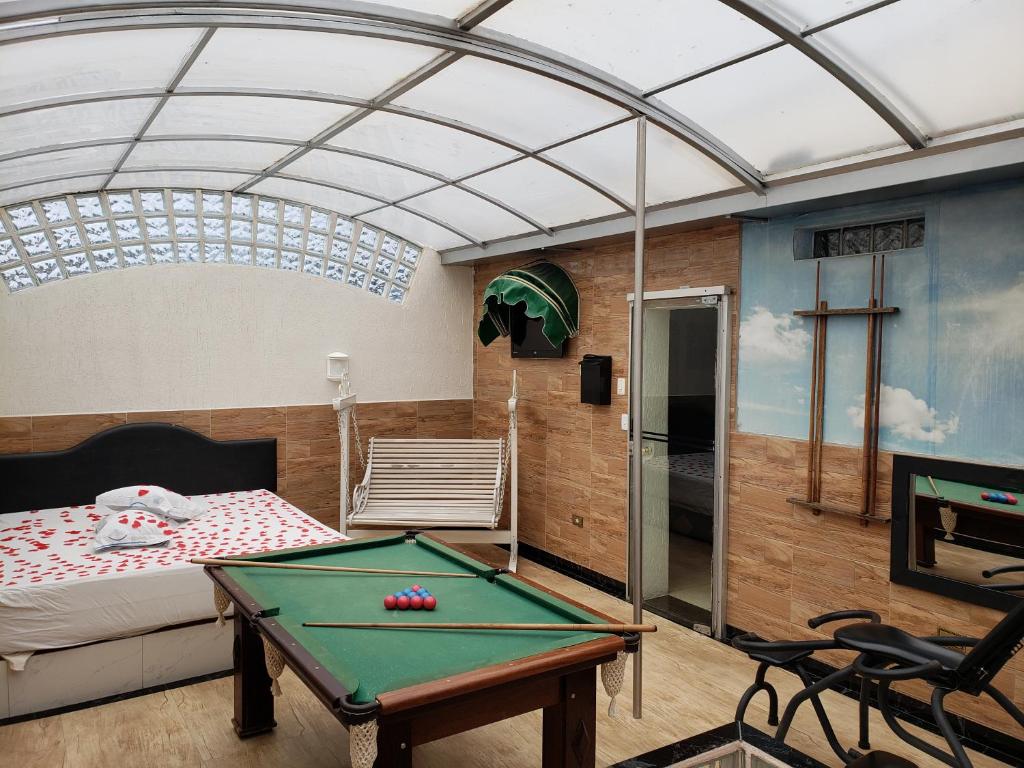 a room with a pool table in a bedroom at Motel Mont Blanc Gru in Guarulhos