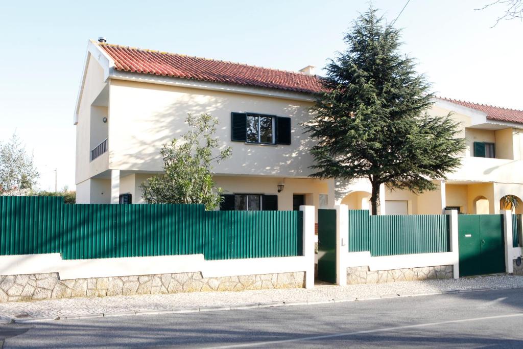a green fence in front of a house at Lisbon Coast Family Home in São Domingos de Rana