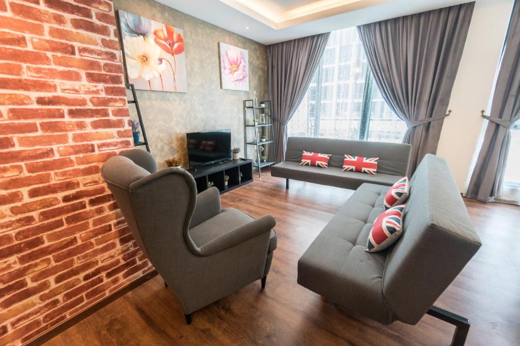 a living room with two chairs and a brick wall at Perfect Getaway @Vivacity in Kuching