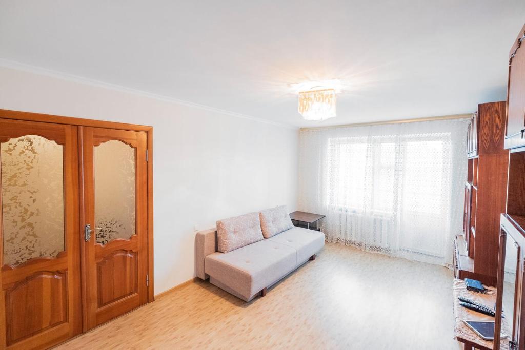 ein Wohnzimmer mit einem Sofa und einem Fenster in der Unterkunft Apartment on Polevaya 44/12 in Bohuslav