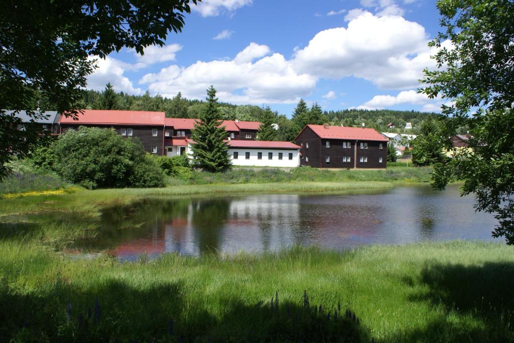 a group of buildings next to a body of water at Penzion Dukla in Mariánská