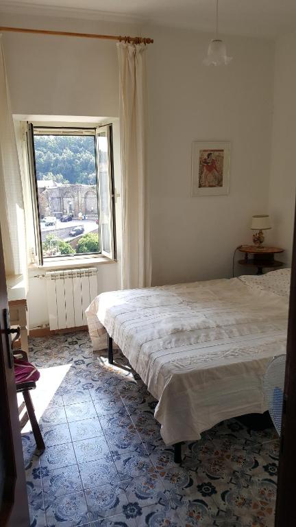 a bedroom with two beds and a large window at Casa Belvedere in Mazzano Romano