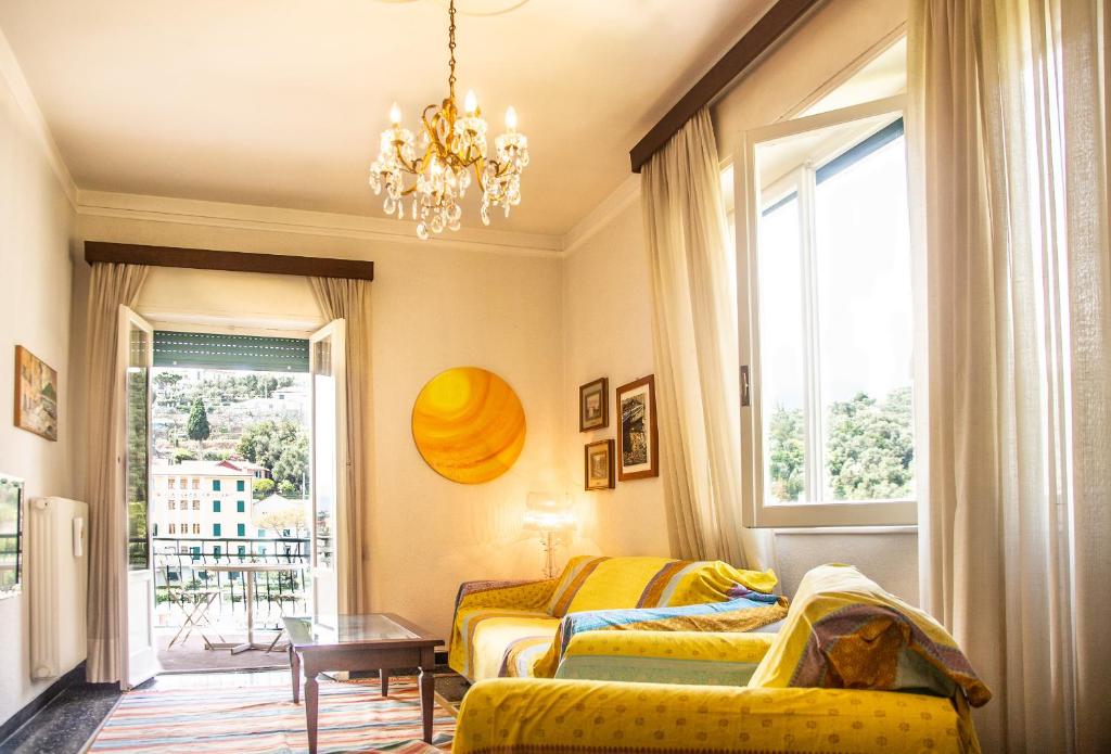 een woonkamer met 2 bedden en een kroonluchter bij San Rocco Flexyrent - Parking - WiFi - Aircon in Rapallo