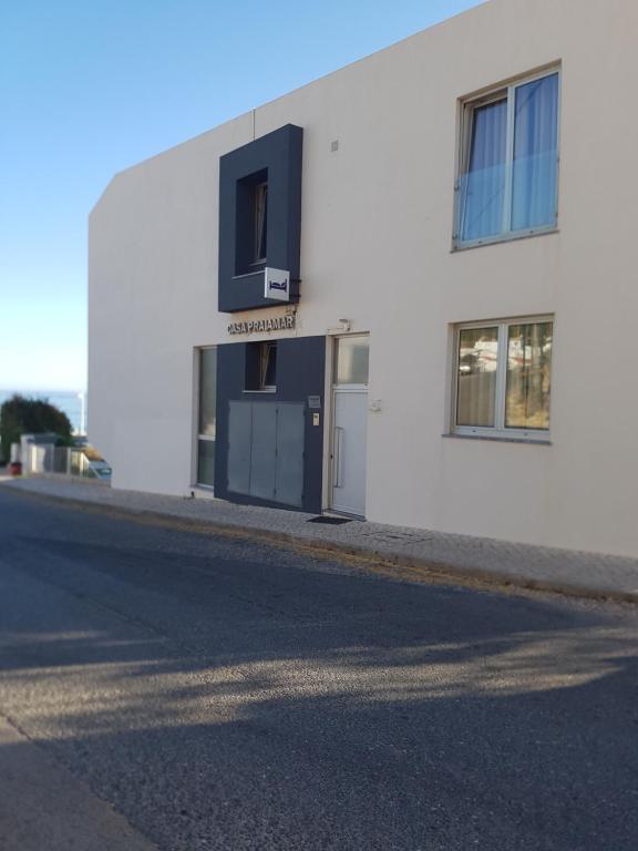 a white building with a door on the side of a street at Casa Praia Mar in Salema