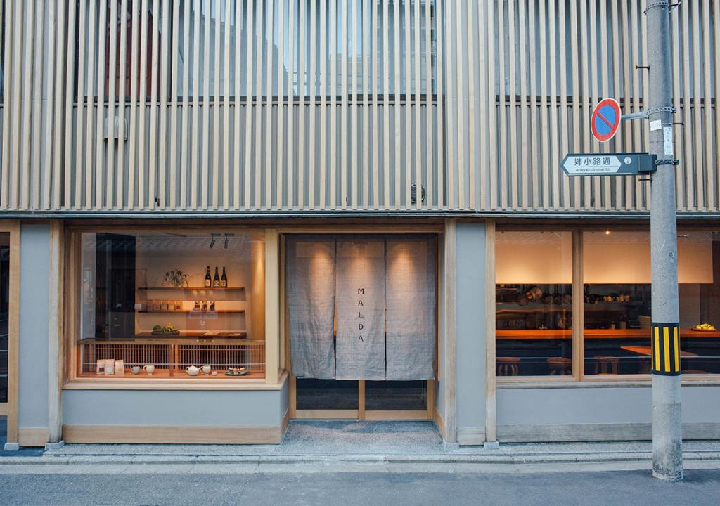 een winkel voor een gebouw met ramen bij Malda Kyoto in Kyoto