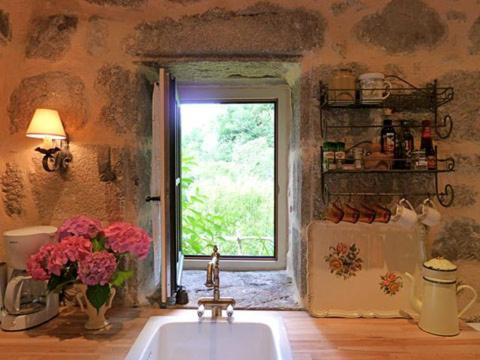 een keuken met een spoelbak en een raam bij Le Studio in Entraygues-sur-Truyère