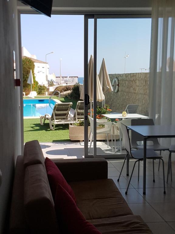 a living room with a couch and a view of a pool at Casa Praia Mar in Salema