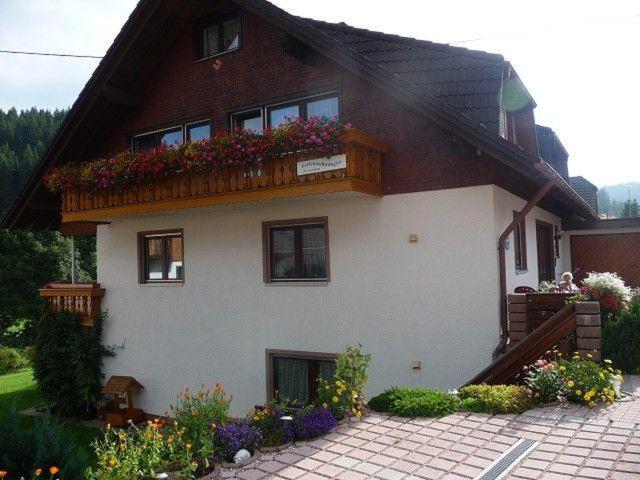 ein Haus mit einem Balkon mit Blumen darauf in der Unterkunft Ferienwohnung Nr.1 in Vöhrenbach
