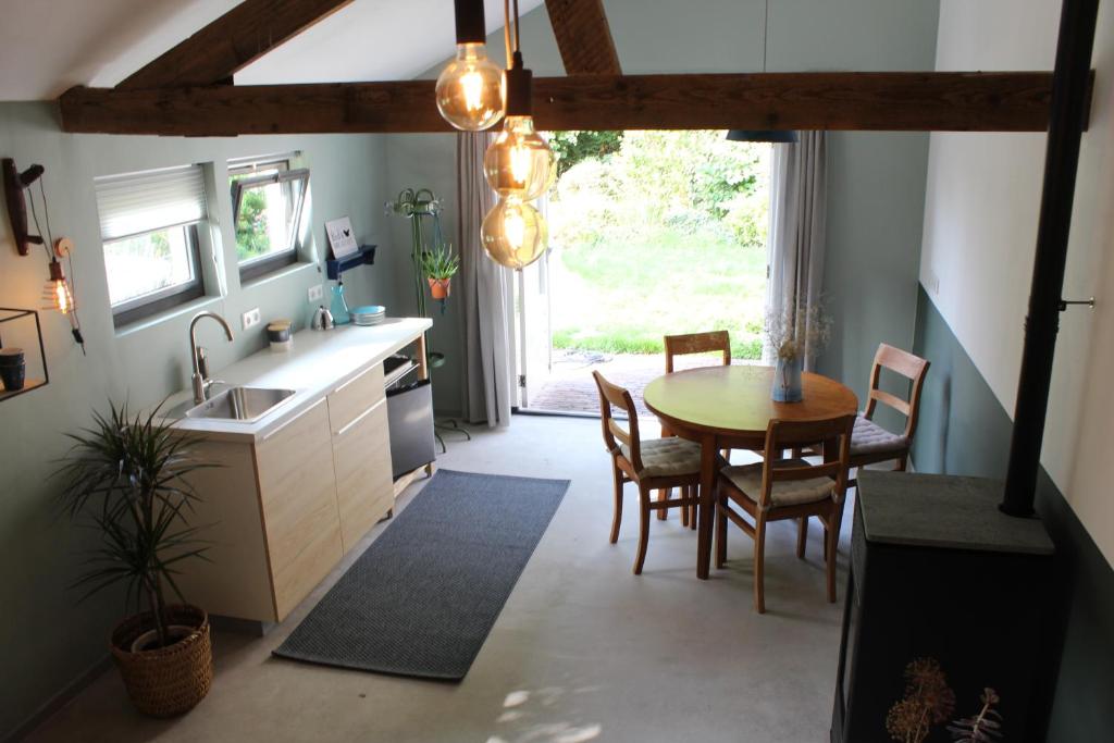 a kitchen and dining room with a table and chairs at Het Aambeeld in Wanroij