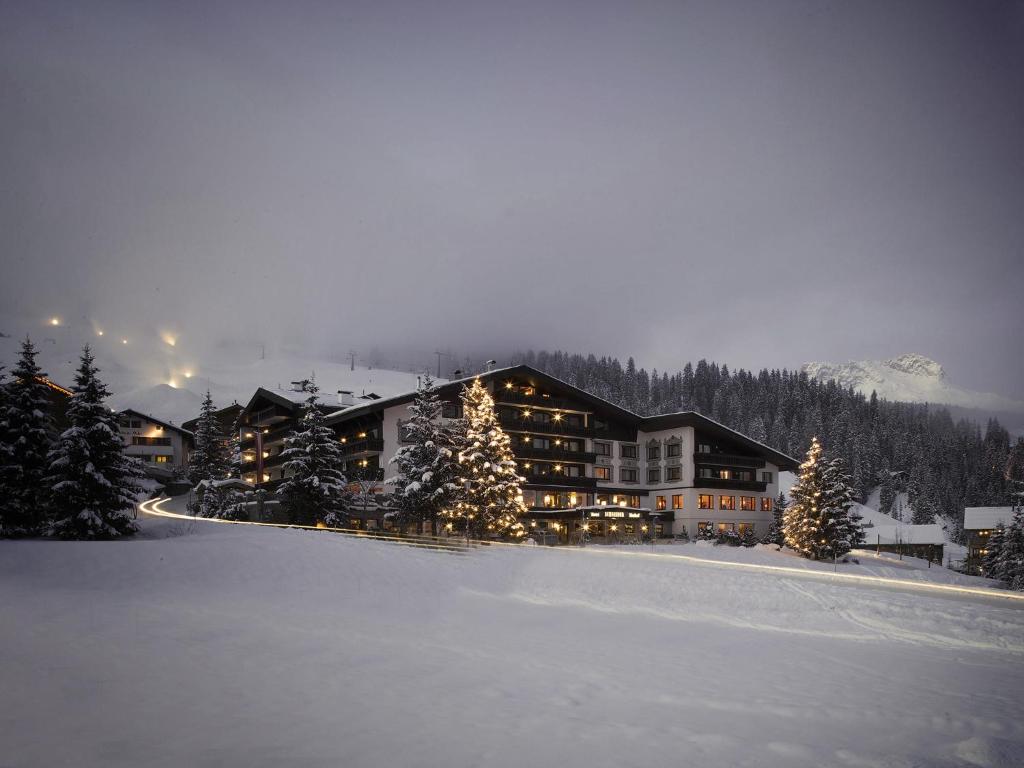 a lodge in the snow with christmas trees at Hotel Almhof Schneider in Lech am Arlberg
