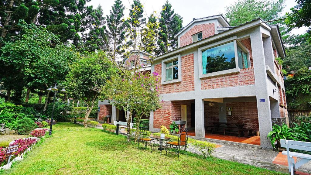 een huis met een tuin met tafels en stoelen bij Red Brick Villas in Nanzhuang