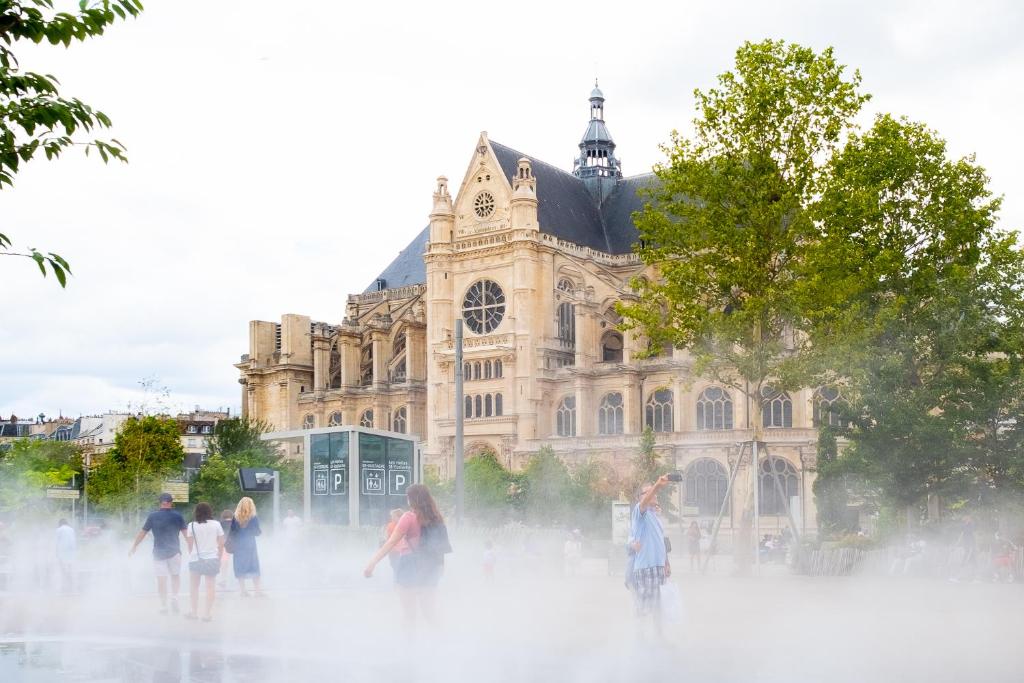 people standing around a fountain in front of a building at Hôtel Crayon in Paris