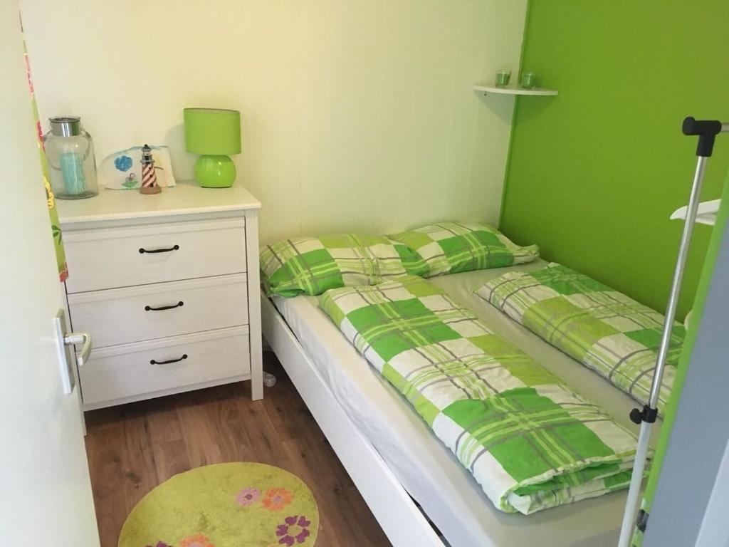 Dormitorio pequeño con cama y vestidor en Beach Chalet am Wasser Nr. 169, en Andijk