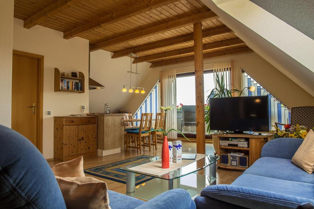 a living room with a blue couch and a tv at Ferienwohnung Dienst in Hagenburg