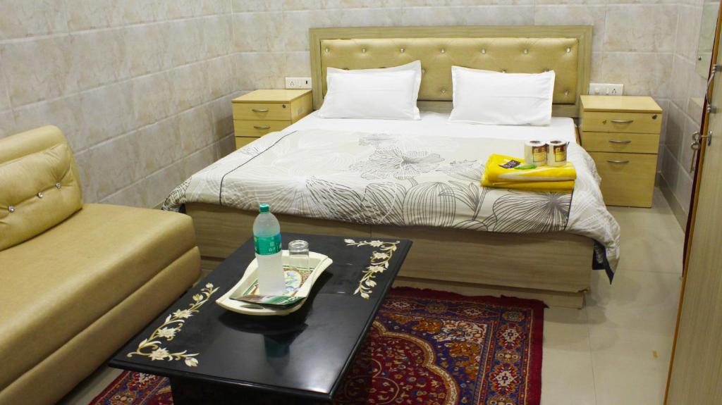 a bedroom with a bed with a table and a couch at Su- Koon Homestay in Agra