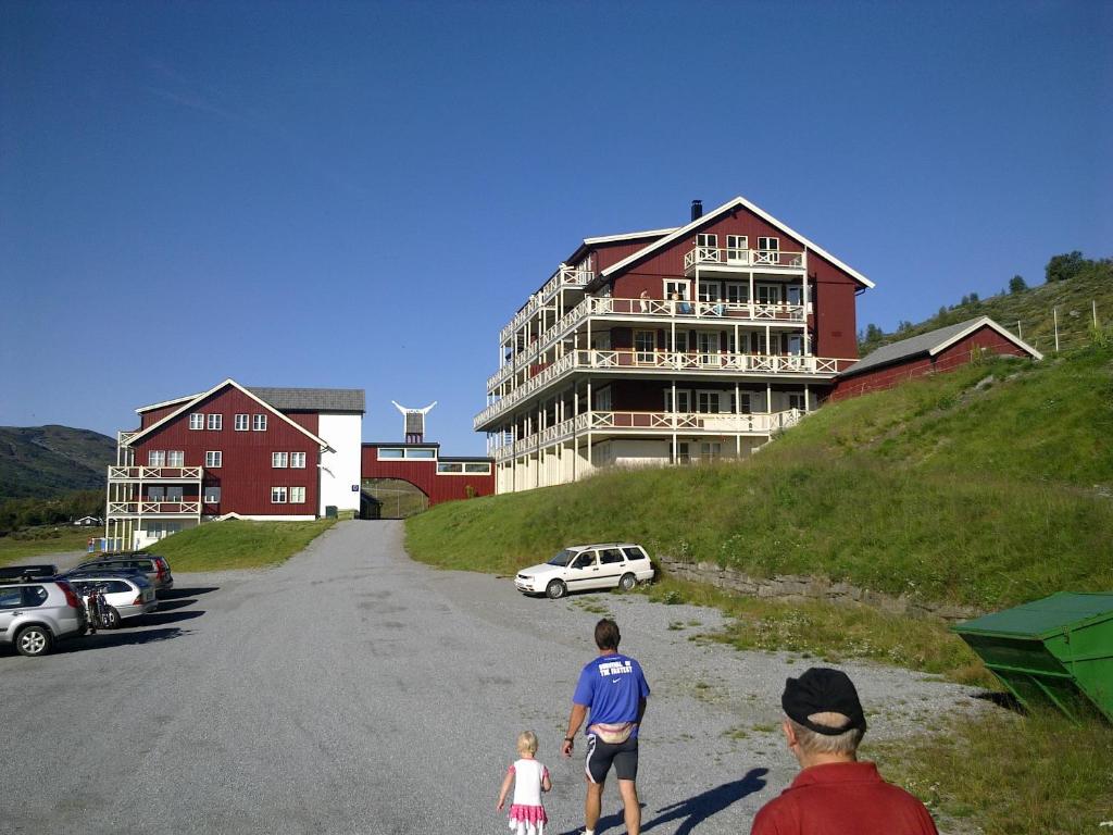 un grupo de personas caminando por un camino delante de un edificio en Nystuen en Tyinkrysset