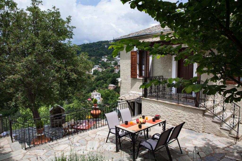 Villa Evridiki by Pelion Esties في أجيوس جورجيوس نيلياس: طاولة وكراسي على شرفة منزل
