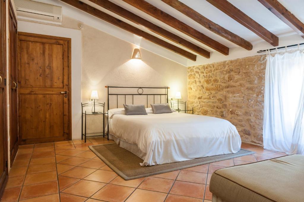 a bedroom with a bed and a stone wall at Hotel Can Simo in Alcudia