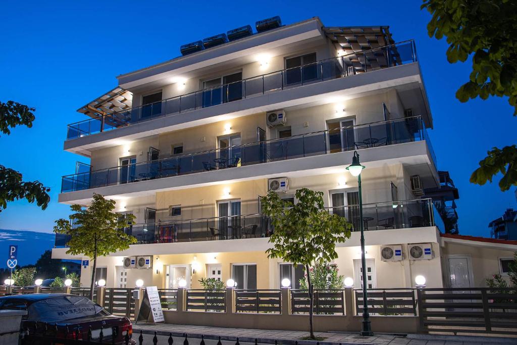 a white building with balconies and a car parked in front at Olympic Coast in Olympic Beach
