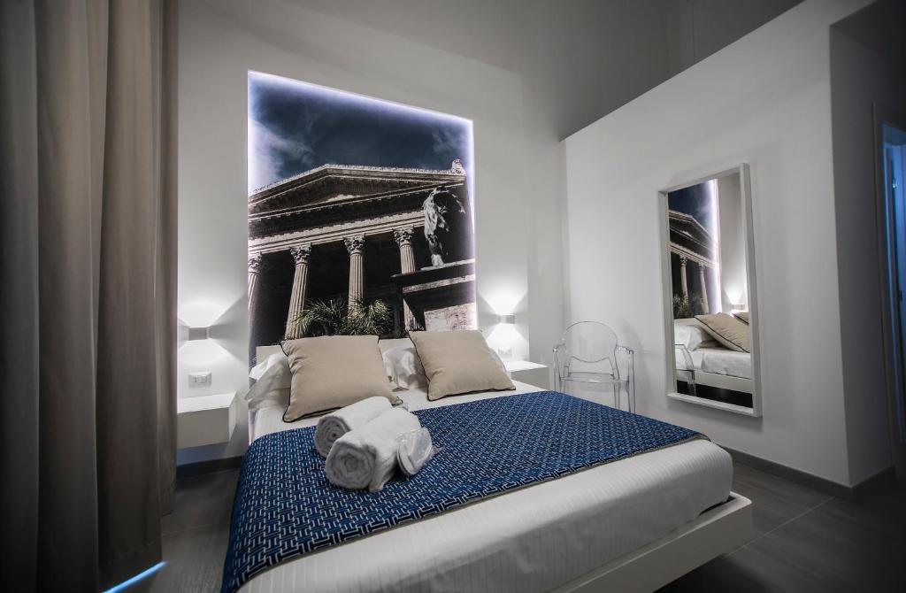 een slaapkamer met een groot bed en handdoeken bij Suite Quaroni in Palermo