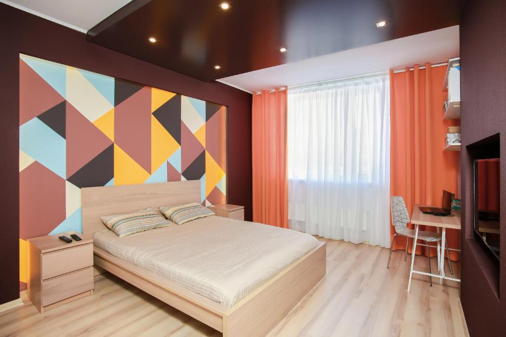 エカテリンブルクにあるアパートメント アルテックのカラフルな壁のベッドルーム1室(ベッド1台付)