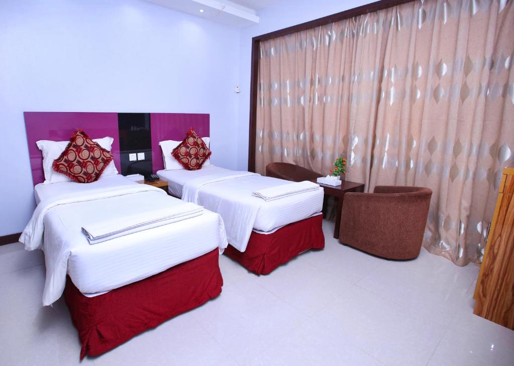 a hotel room with two beds and a window at Zagy Hotel in Dubai