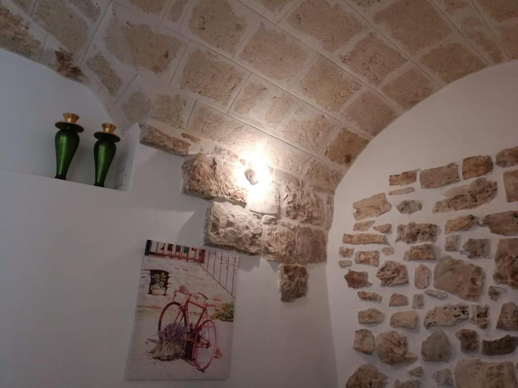 a room with a stone wall and two vases on a wall at L' Edera in Fasano
