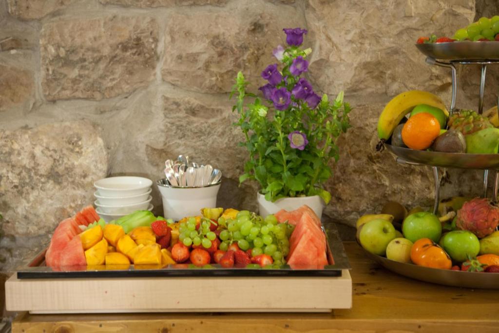 a table topped with a tray of fruits and vegetables at The American Colony Hotel - Small Luxury Hotels of the World in Jerusalem