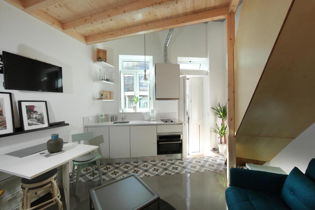 uma cozinha com armários brancos, uma mesa e um balcão em Dubocage45Citycenter em Faro